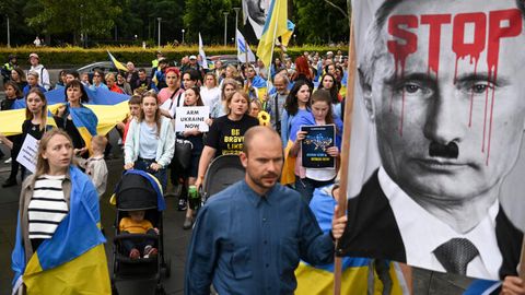 In Sydney versammeln sich Mitglieder der ukrainischen Gemeinde vor der St. Mary's Kathedrale zu einer Mahnwache. Ein Plakat zeigt Russlands Präsident Putin mit Hitlerbart, auf seiner Stirn steht in roter Farbe "Stop".