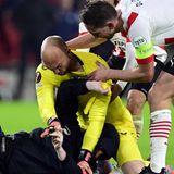 Dmitrovic nimmt den Schläger in die Mangel und Eindhoven-Profis eilen hinzu, um den Keeper von Schlimmeren abzuhalten. "Es ist niemals gut, das im Fußball zu sehen, das sollte nicht passieren und ich hoffe, dass diese Dinge bestraft werden", sagt Dmitrovic zu dem Angriff. "Ich kann mir vorstellen, dass er sauer wegen des Ergebnisses von PSV war. Wenn mich jemand angreift, verteidige ich mich. Er hat versucht mich zu schlagen, aber ich konnte ihn festhalten und warten, bis die Sicherheitsleute kommen."