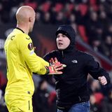 Ein Albtraum für jeden Spieler: Ein Anhänger von PSV Eindhoven rennt in der Nachspielzeit auf den Rasen und greift den Torwart des FC Sevilla Marko Dmitrovic, an.