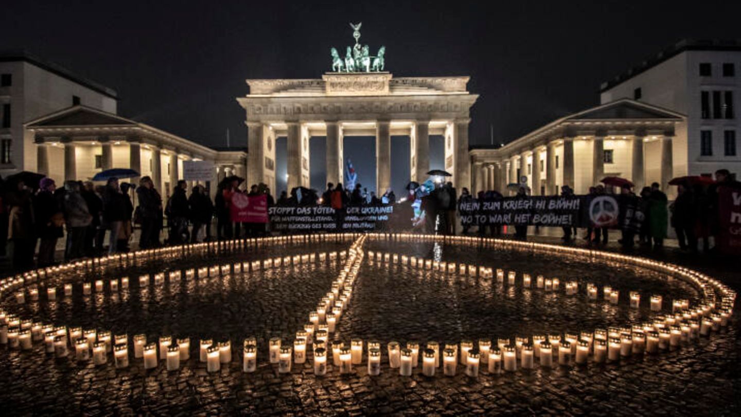 Vor dem Brandenburger Tor in Berlin stellen Aktivisten ein übergroßes Peace-Zeichen aus Kerzen auf. Später soll hier eine Solidaritätsdemo unter dem Motto "Das Ungeheuerliche nicht hinnehmen" stattfinden.