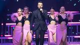 Giovanni Zarrella singt neben Tänzerinnen in ein Mikrofon