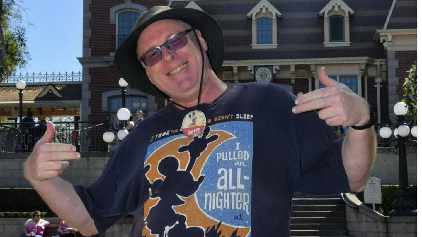 Jeff Reitz steht stolz im Disneyland und trägt ein T-Shirt mit einem Motiv des Vergnügungsparks