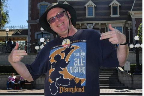 Jeff Reitz steht stolz im Disneyland und trägt ein T-Shirt mit einem Motiv des Vergnügungsparks