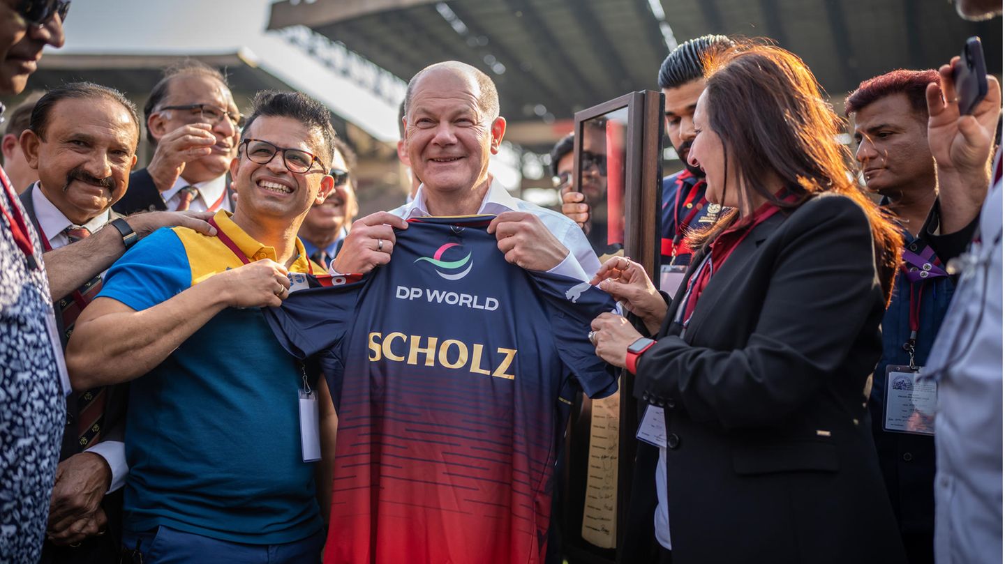 Bundeskanzler Olaf Scholz bekommt bei seinem Besuch in Indien ein Cricket-Trikot überreicht