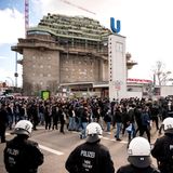 Rostocks Anhänger laufen hinter einer Polizeikette ins Stadion.