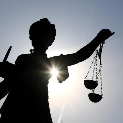 Die Statue der Justitia steht mit einer Waage und einem Schwert Die Statue der Justitia steht mit einer Waage und einem Schwert