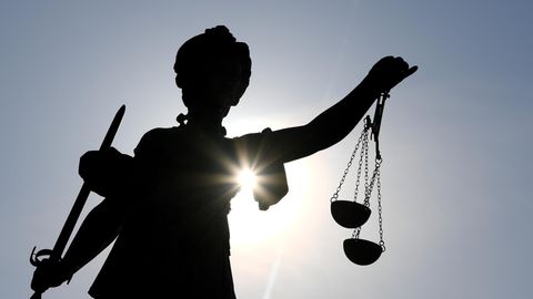 Die Statue der Justitia steht mit einer Waage und einem Schwert
