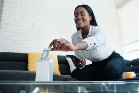 Fotodrucker für Handy: Eine Frau nimmt ein Bild aus ihrem Fotodrucker für das Handy.
