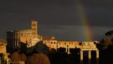 Ein Regenbogen leuchtet über dem Forum Romanum und dem Kolosseum – vor einem tiefschwarzen Himmel