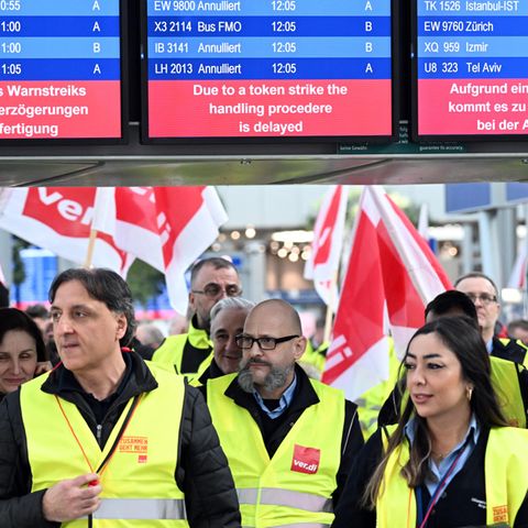 Streikende Flughafen-Mitarbeiter stehen mit Verdi-Flaggen im Terminal des Flughafens in Düsseldorf 