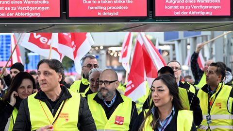 Streikende Flughafen-Mitarbeiter stehen mit Verdi-Flaggen im Terminal des Flughafens in Düsseldorf 