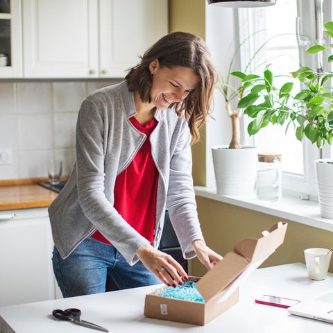 Frau packt ein Paket ein