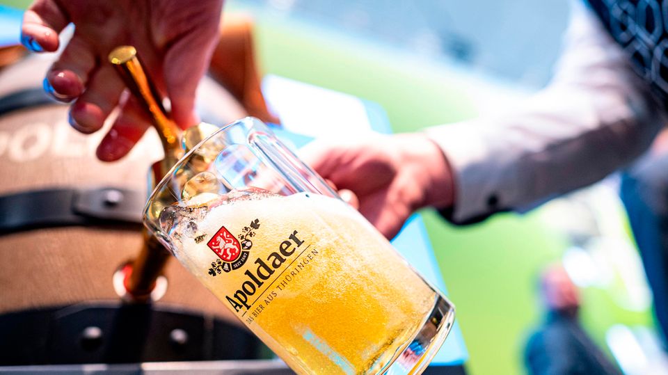 Ein Mann zapft Bier in einen Glaskrug