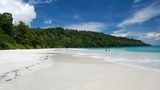 Wunderschön, schwer erreichbar und naturbelassen, das ist der Radhanagar Beach auf der Havelock Island im Indischen Ozean. Die Insel gehört zur Inselgruppe der Andamanen und Nikobaren. Der weiße Sandstrand ist umgeben von reiner Natur und gilt bei Touristen in dem Gebiet als Geheimtipp. Liegestühle und Strandbars suchen Besucher deshalb vergeblich, dafür bekommen sie aber ruhige Momente am rauschenden Meer. 