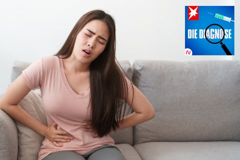 Ein Mädchen krümmt sich vor Bauchschmerzen