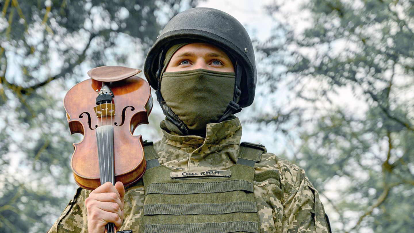 Ukrainischer Soldat spielt mit seiner Violine im Kriegsgebiet Ukrainischer Soldat spielt mit seiner Violine im Kriegsgebiet