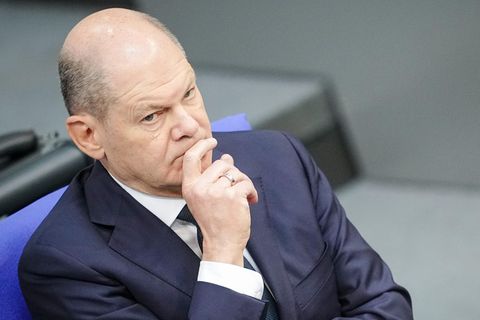 Bundeskanzler Olaf Scholz verschränkt die Arme und denkt nach