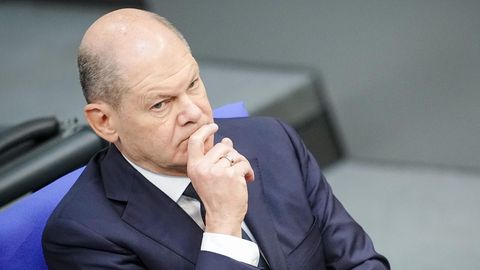 Bundeskanzler Olaf Scholz verschränkt die Arme und denkt nach