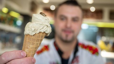 Thomas Micolino, Inhaber des Eiscafé Rino, zeigt ein Eis, das zum Teil aus Grillenmehl besteht