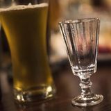 Ein volles Bierglas neben einem leeren Vodka-Glas