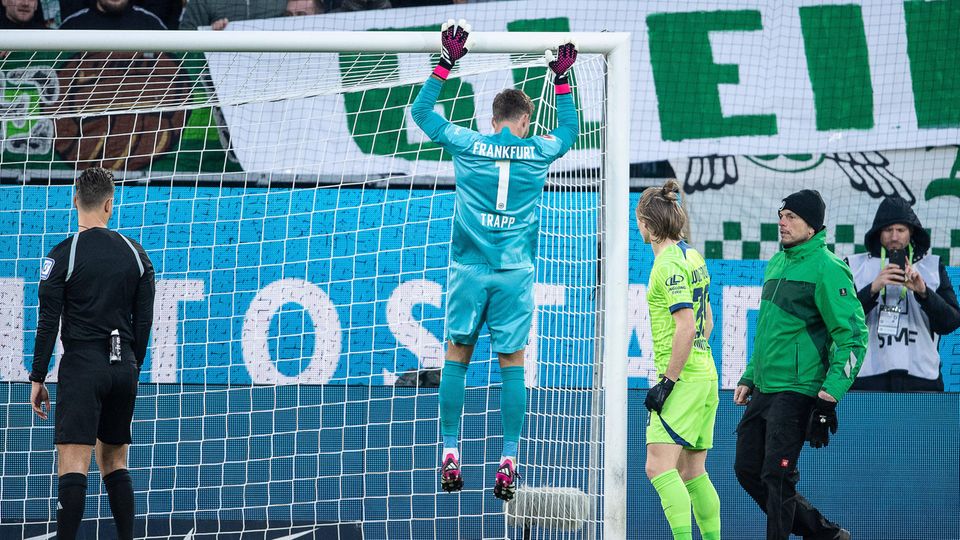 Eintracht Frankfurt goalkeeper Kevin Trapp hangs on the crossbar in the Bundesliga game against Wolfsburg