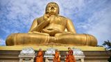 Narathiwat, Thailand. Buddhistische Mönche umrunden eine riesige goldene Buddha-Statue. Denn sie begehen den Feiertag Makha Bucha – oder auch Magha Puja. Der Überlieferung nach versammelten sich an diesem Tag 1250 Mönche aus allen Himmelsrichtungen spontan zu einer Predigt Buddhas, bei der er seinen Tod in drei Monaten korrekt vorhersagte. Am Tag des dritten Vollmondes eines Jahres strömen die Gläubigen in Thailand in die Tempel, um den Mönchen Almosen zu bringen und ihren Predigten zu hören. 
