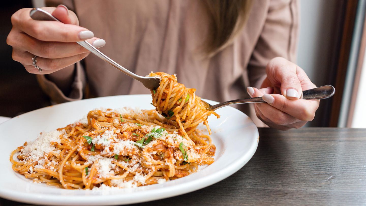 Eine Frau mit italienischem Essen. Auf Fischgerichte würde übrigens kein Parmesan gehören.