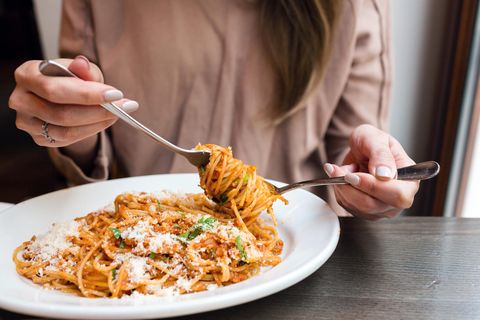 Eine Frau mit italienischem Essen. Auf Fischgerichte würde übrigens kein Parmesan gehören.