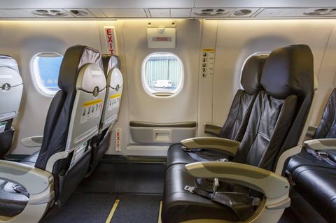 Leere Sitzreihen und Tür in Flugzeug