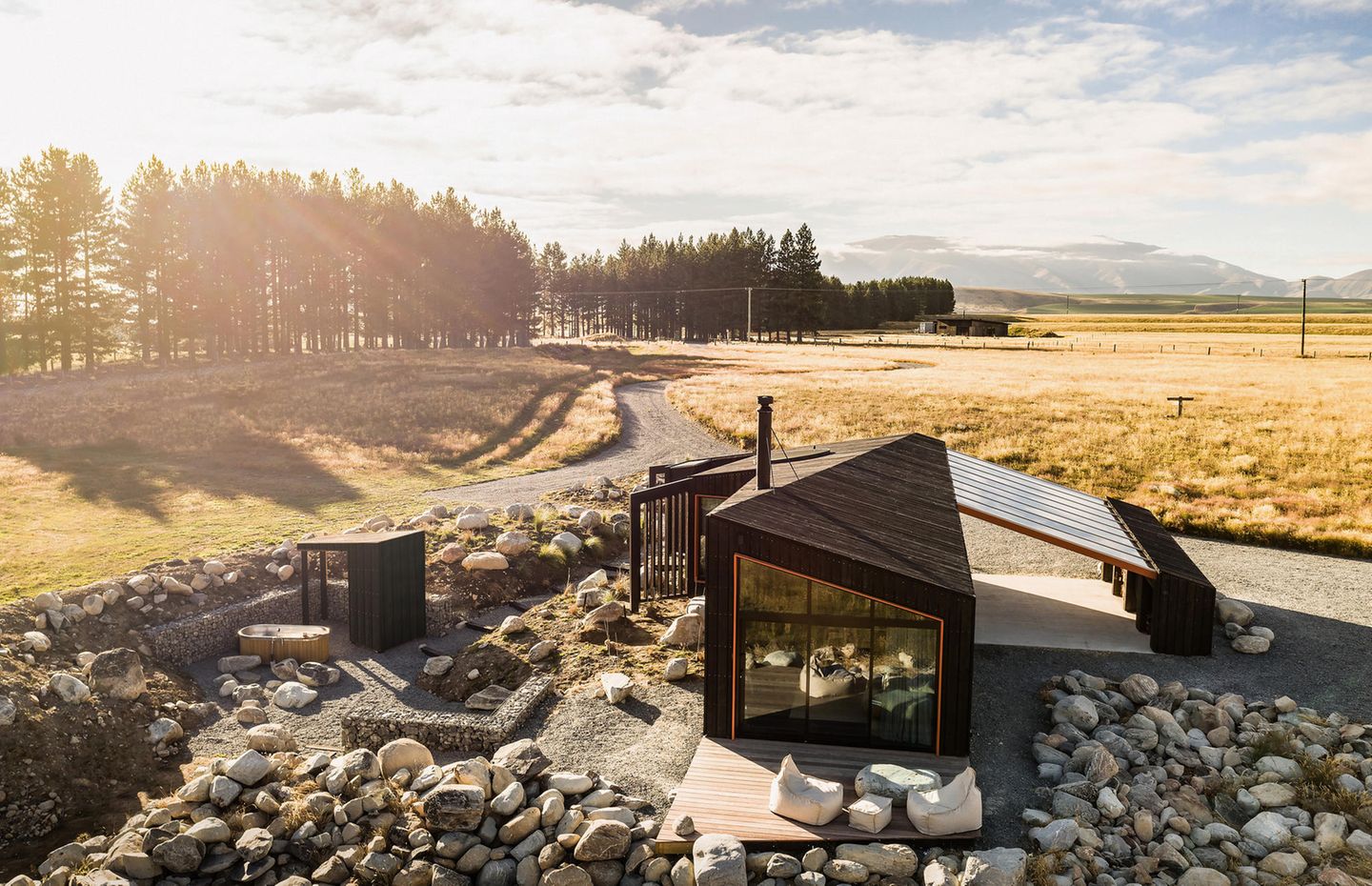 50 Quadratmeter misst die Wohnfläche dieses Hauses, das im Örtchen Twizel in Neuseeland steht. Mit dieser Minilodge wollte sich der Bauherr einen Rückzugsort nahe der Ben Ohau Range schaffen. Die Raumwinkel wurden so berechnet, dass sich aus jedem Zimmer eine andere Aussicht darbietet. Das kreisrunde Oberlicht über dem Bett gibt zum Beispiel die Sicht auf das Mackenzie Aoraki International Dark Sky Reserve frei. Für die Innenräume verwendete der Architekt Barry Connor helles Buchensperrholz, das mit schwarzen Details einen Kontrast bildet. 