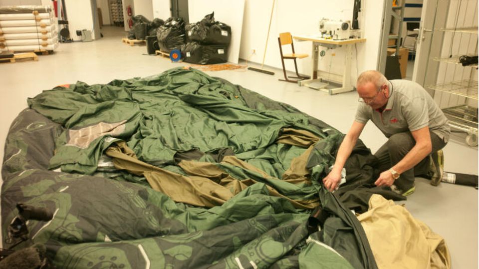 An employee spreads a dummy multiple rocket launcher on the floor before inflating it