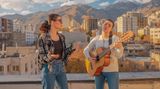 Iran: Zwei junge Frauen singen. Eine von beiden spielt Gitarre.