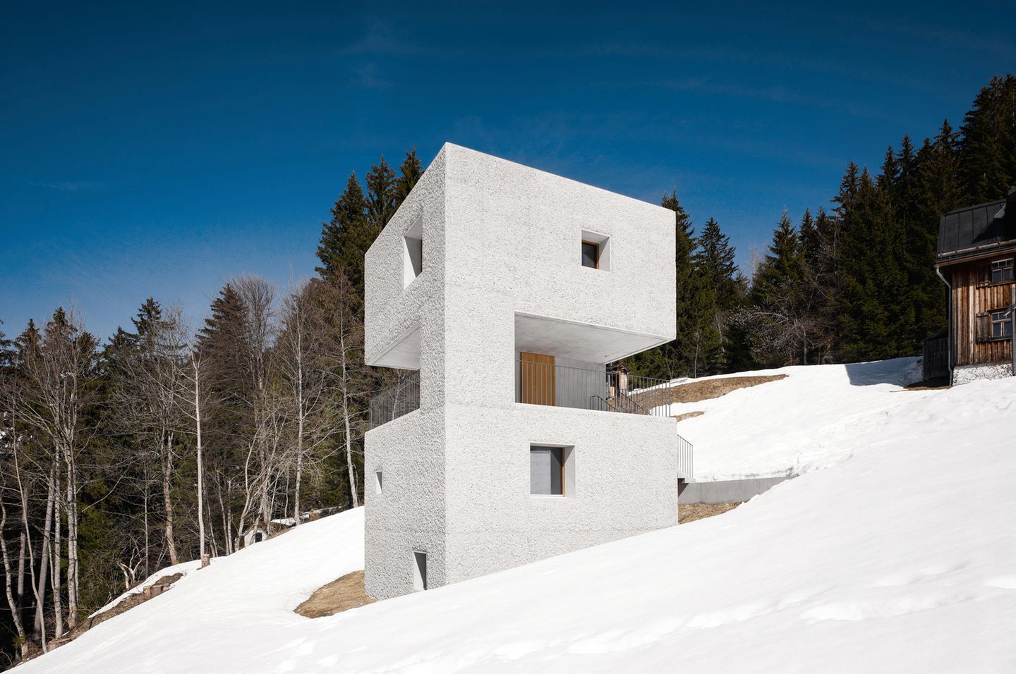 Bei dem Entwurf zu diesem Haus war es dem Architekten-Duo Bernhard und Stefan Marte besonders wichtig, die Landschaft nicht zu verändern. Das Grundstück misst 485 Quadratmeter, während das Haus nur 87 Quadratmeter an Wohnfläche bietet. Das turmähnliche Gebäude hat eine Grundfläche von 43 Quadratmetern und wurde 2011 errichtet. Der Bau aus rauem Beton öffnet sich seiner Umgebung durch quadratische, unterschiedlich große Fenster. Im Inneren herrscht ein strenger Materialmix aus rohen Betonwänden und unbehandelten Eichenböden. 