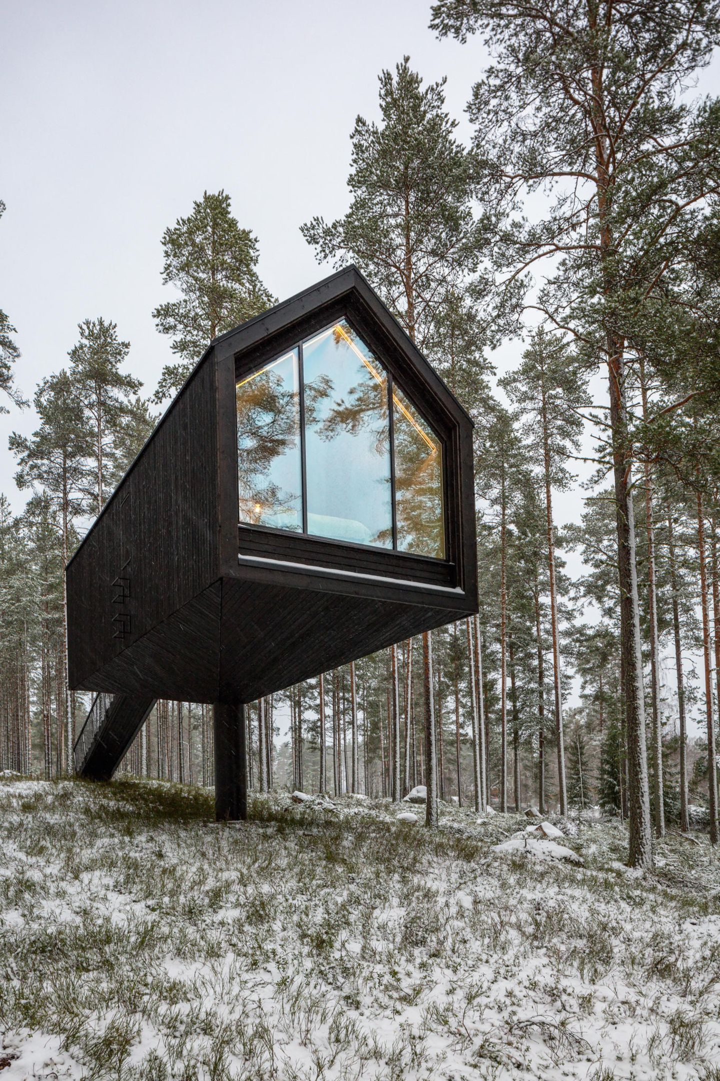 Dieses Modell ist kein privates Haus, sondern Teil des Kivijärvi Resorts. Wegen des Salamajärvi-Nationalparks musste es sorgfältig geplant werden, um die Natur zu schonen. Die Architekten entschieden sich für drei Unterkunftsvarianten. Der hier gezeigte Prototyp ist vom Boden angehoben. Das Bauwerk balanciert auf einem einzigen Pfeiler. Durch das raumhohe Fenster lässt sich die Landschaft überblicken. 