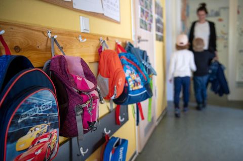 Kinderrucksäcke hängen im Eingangsbereich eines Kindergartens.