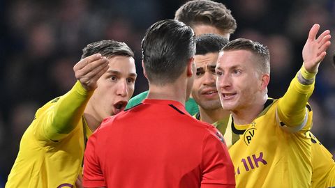 Die Dortmunder Nico Schlotterbeck (links) und Marco Reus reden auf Schiedsrichter Danny Makkelie ein.