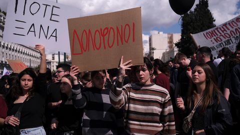 Menschen halten Plakate hoch, auf denen in griechisch die Worte «Mörder» und «Nie wieder!» stehen