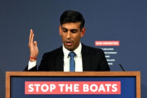 Rishi Sunak, britischer Premier, spricht an einem Rednerpult mit "Stop the boats"-Schriftzug