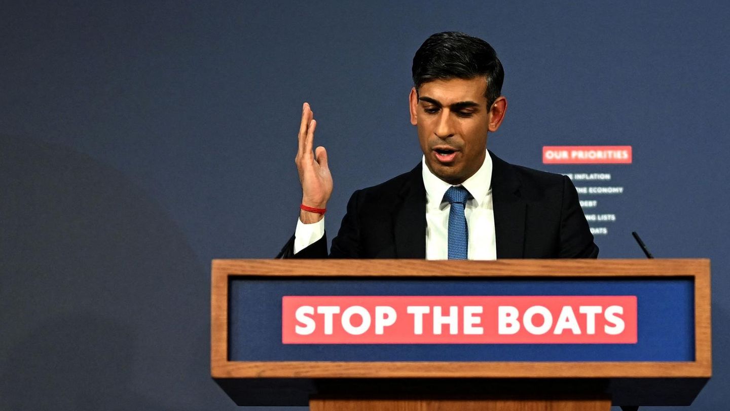 Rishi Sunak, britischer Premier, spricht an einem Rednerpult mit "Stop the boats"-Schriftzug