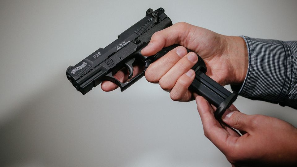Ein Mann lädt eine Schreckschuss-Pistole "Walther P22" mit einem Magazin. Etwa tausend Extremisten haben eine Waffenerlaubnis.