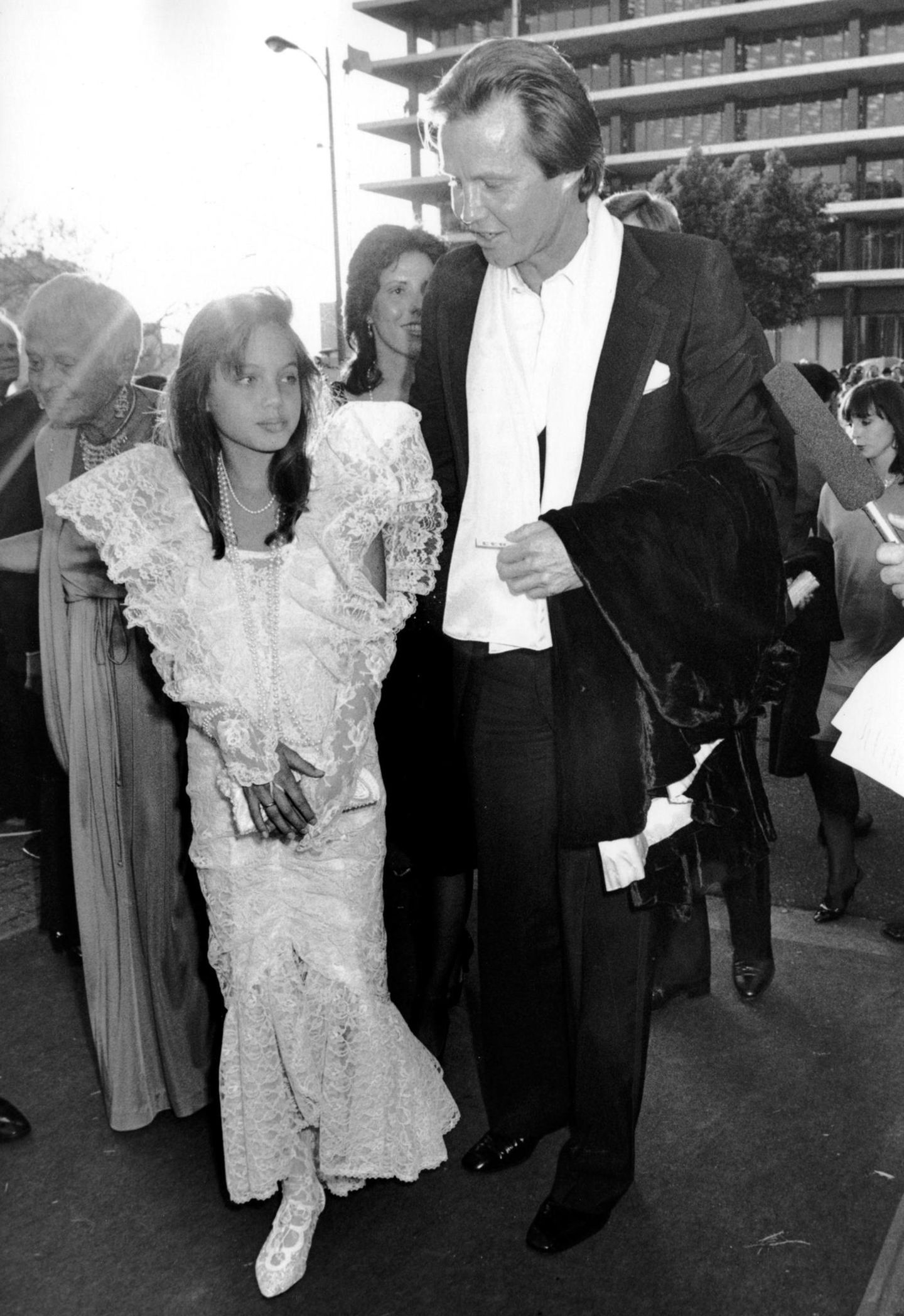 Früh stylt sich: Angelina Jolie begleitet ihren Vater Jon Voight 1986 im weißen Spitzenkleid zu den Oscars