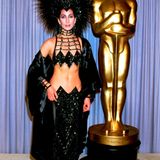 Molto schrill: Cher bei den Oscars 1986 mit Federkopfschmuck und bauchfreiem Zweiteiler