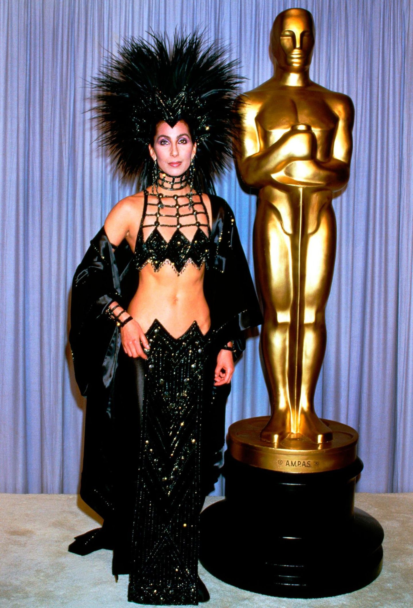 Molto schrill: Cher bei den Oscars 1986 mit Federkopfschmuck und bauchfreiem Zweiteiler