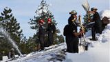 Mitglieder der kalifornischen Nationalgarde schaufeln in der Kleinstadt Crestline Schnee von einem Dach