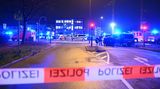 Am Tatort eines Amoklaufes in Hamburg überspannt rot-weißes Absperrband der Polizei eine mehrspurige Straße voller Polizeiautos