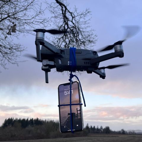 Smartphone hängt an einer Drohne