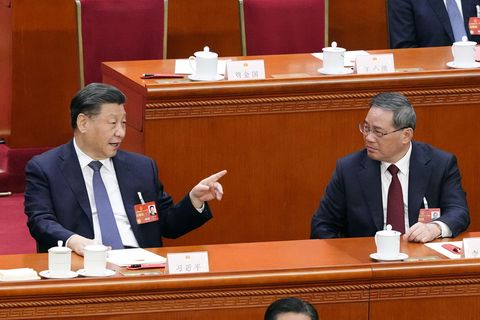 Xi Jinping (l), Chinas Staats- und Parteichef, und Li Qiang, unterhalten sich während einer Plenarsitzung des Nationalen Volkskongresses (NVK) im Rahmen der Jahrestagung des NVK in der Großen Halle des Volkes. Li wurde auf der Tagung zum Ministerpräsidenten gewählt.