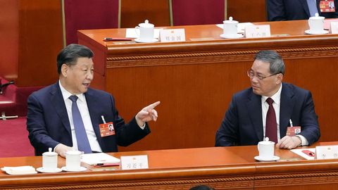 Xi Jinping (l), Chinas Staats- und Parteichef, und Li Qiang, unterhalten sich während einer Plenarsitzung des Nationalen Volkskongresses (NVK) im Rahmen der Jahrestagung des NVK in der Großen Halle des Volkes. Li wurde auf der Tagung zum Ministerpräsidenten gewählt.