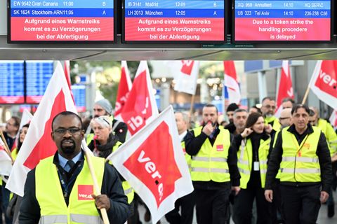 Streikende Flughafen-Mitarbeiter stehen Ende Februar mit Verdi-Flaggen im Terminal des Flughafens Düsseldorfs.