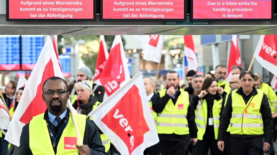 Streikende Flughafen-Mitarbeiter stehen Ende Februar mit Verdi-Flaggen im Terminal des Flughafens Düsseldorfs.